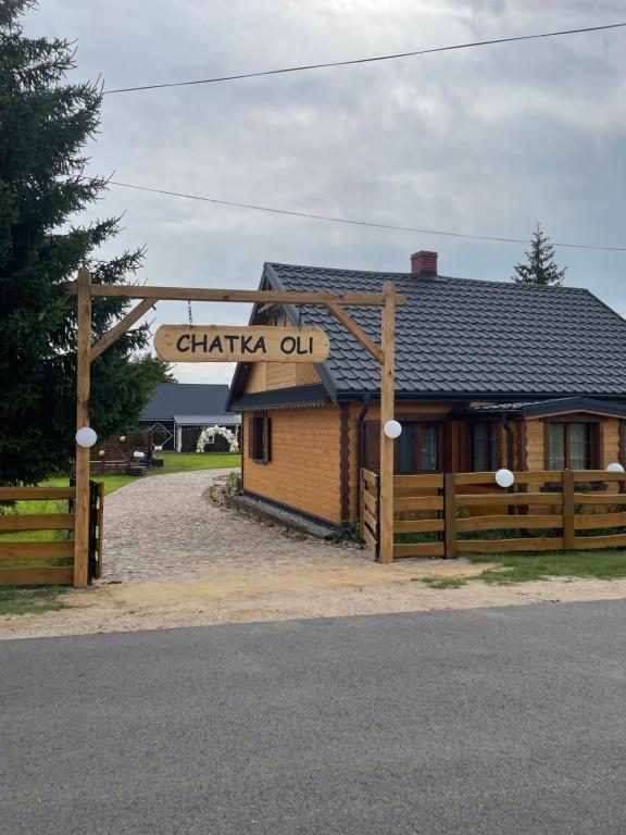 a sign for a chateau oil with a building at Chatka Oli in Zubacze
