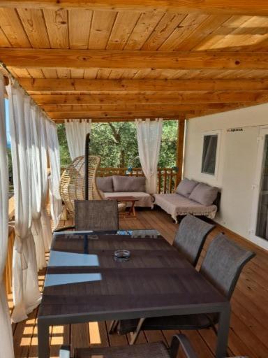 a wooden table and chairs in a living room at Mobile Homes Plava Laguna in Pakoštane