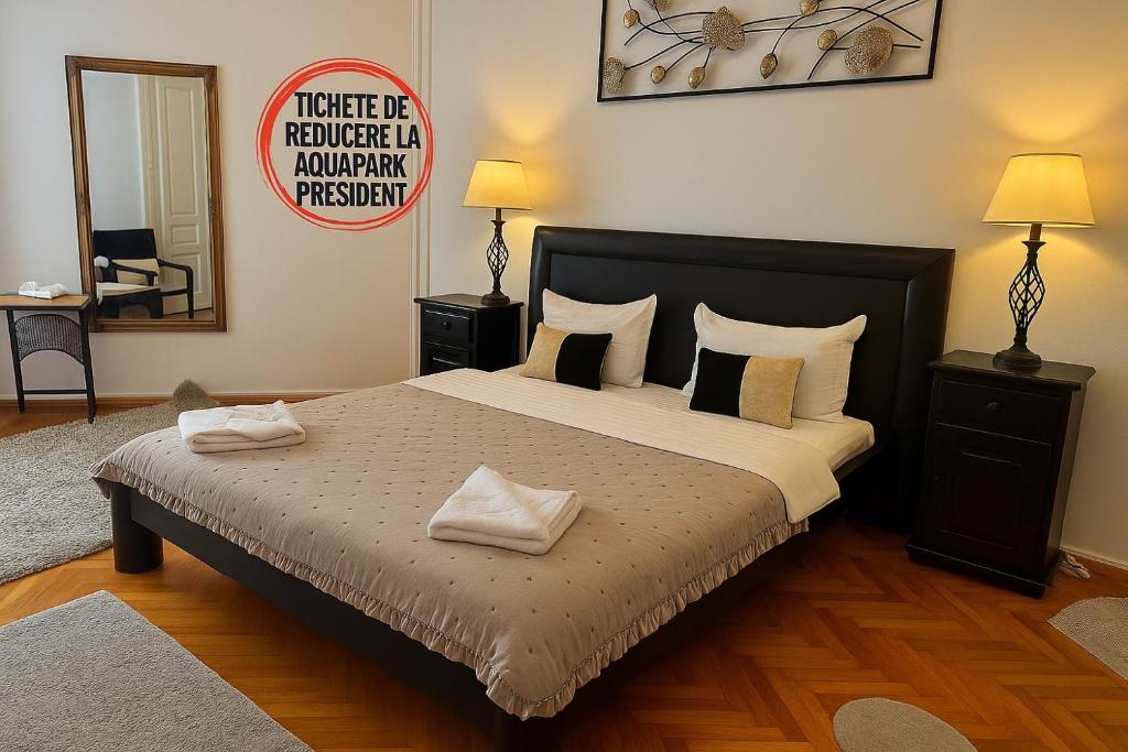 a bedroom with a bed with pillows and a sign at Mid Ultra Central Apartments, Self Check In in Oradea