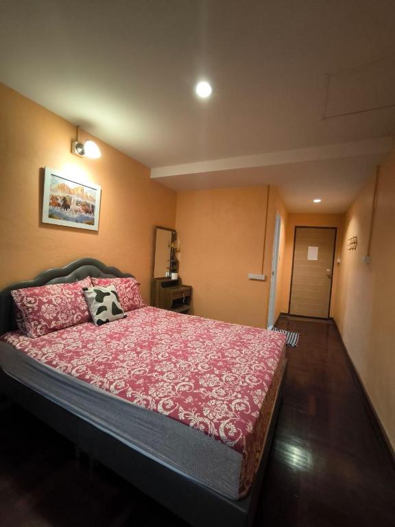 een slaapkamer met een groot bed met een rode sprei bij Santo house Bangkok in Bangkok