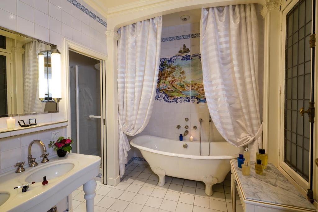 a bathroom with a tub and a sink at Hôtel Raphael in Paris