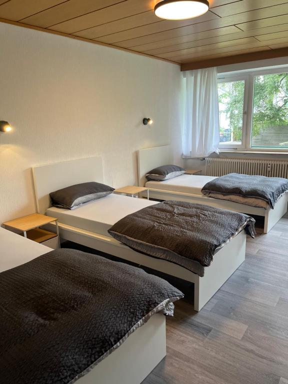 three beds in a room with a window at Stay 15 Kassel in Kassel