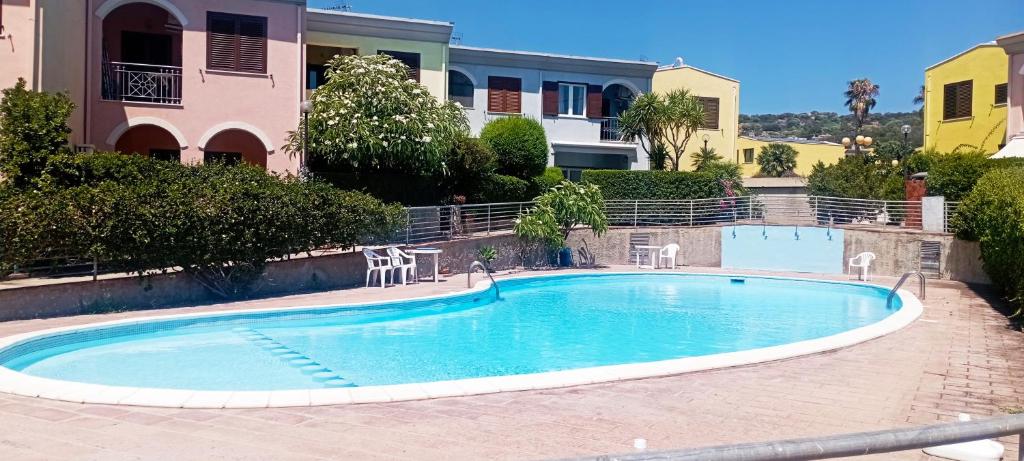 a swimming pool in the middle of a building with chairs around it at Casa Luca ai Borghi di Villasimius in Villasimius