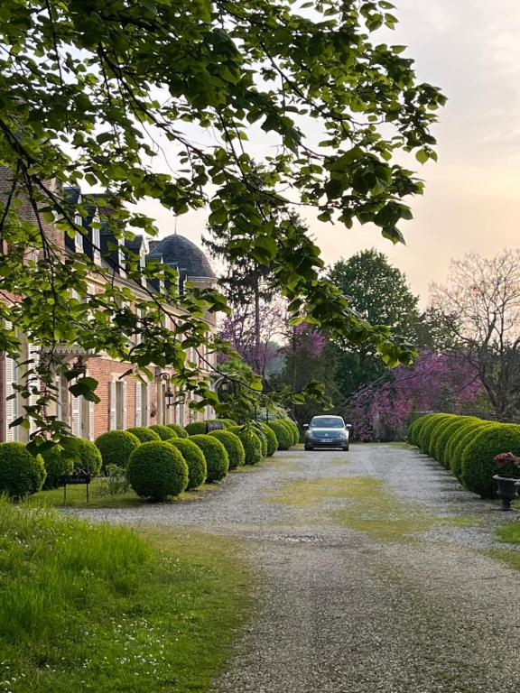 a car driving down a road next to a house at L'Écrin du Marquis 