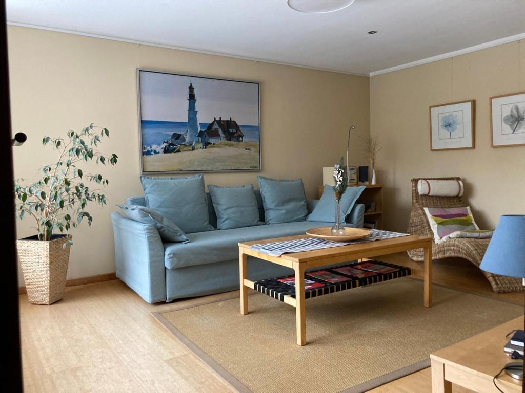 a living room with a blue couch and a table at Ferienwohnung Hempfling in Rostock