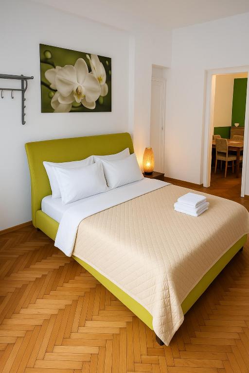 a bedroom with a large bed with a green headboard at Central 2 Budget Accomodation in Bucharest