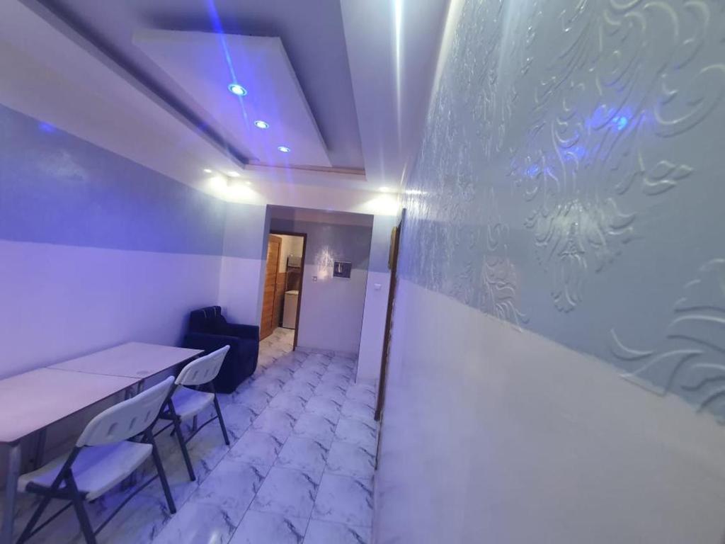 Zimmer mit einem Tisch, Stühlen und einer Wand in der Unterkunft Résidence Hamoudé in Dakar