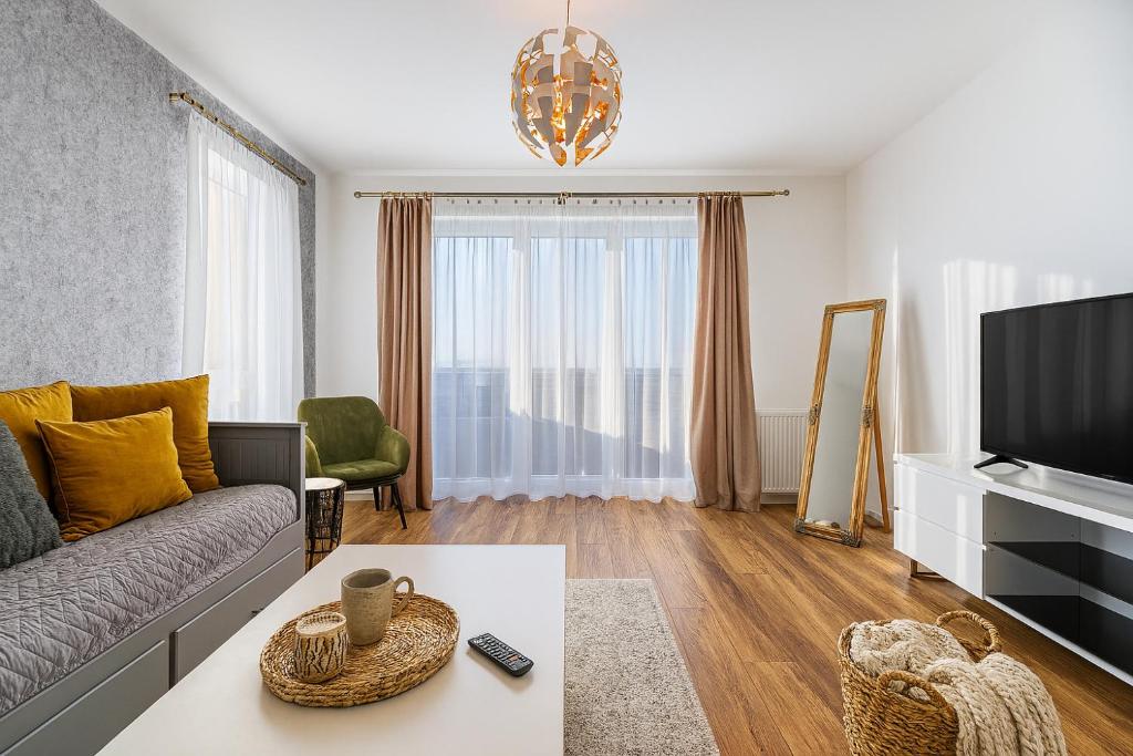 a living room with a couch and a tv at KOA - Sunlight Apartment in Braşov