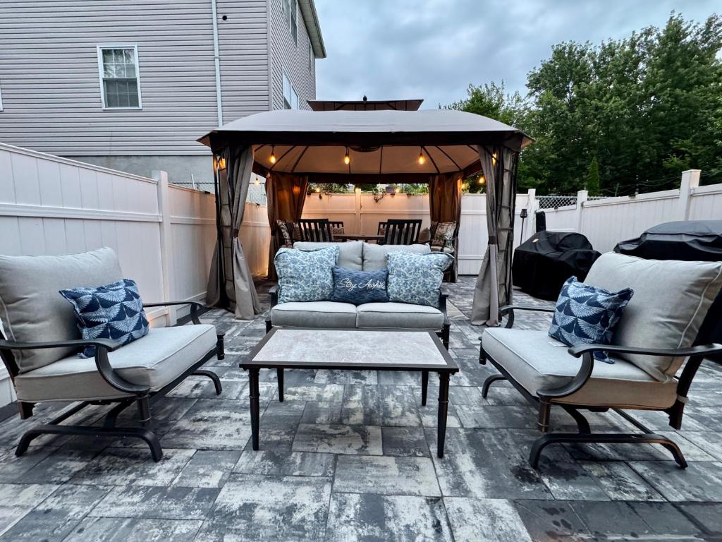 un patio avec un canapé et un gazebo dans l'établissement 2 Bedroom Apartment, Close to NYC & Downtown JC!, à Jersey City