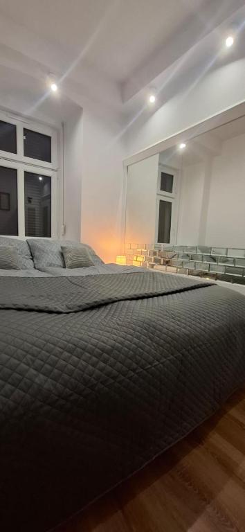 a large bed in a room with a large window at Apartament Antracyt in Wałbrzych
