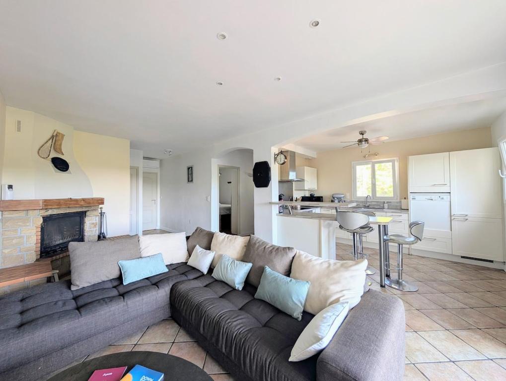 a living room with a couch and a kitchen at Appartement familial 118 m2 proche Bayonne in Hasparren