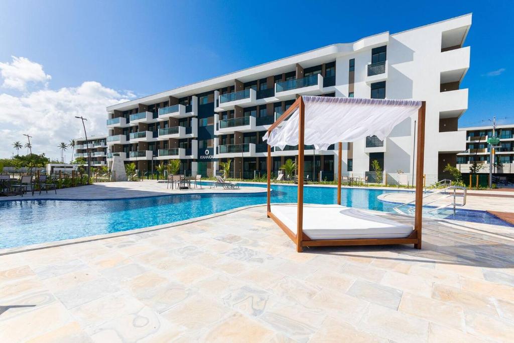 ein Schwimmbad vor einem Gebäude in der Unterkunft Flat Makia Beach Experience Muro Alto Porto de Galinhas in Porto De Galinhas