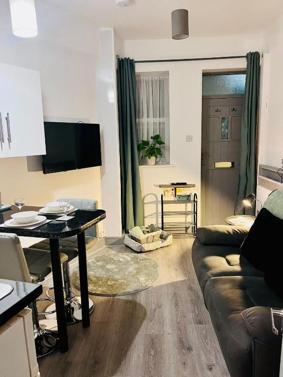 a living room with a couch and a table at Olivias snug in Beverley