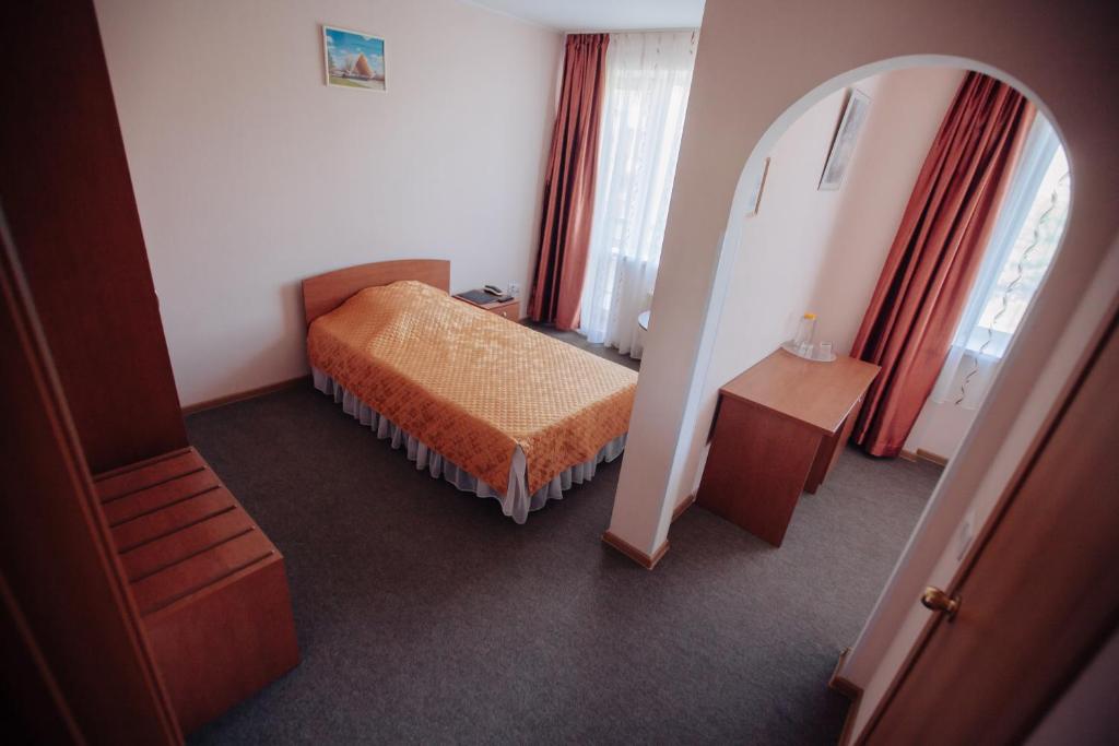 馬格尼托哥爾斯克的住宿－Hotel Silver City，一间小卧室,配有一张床和镜子