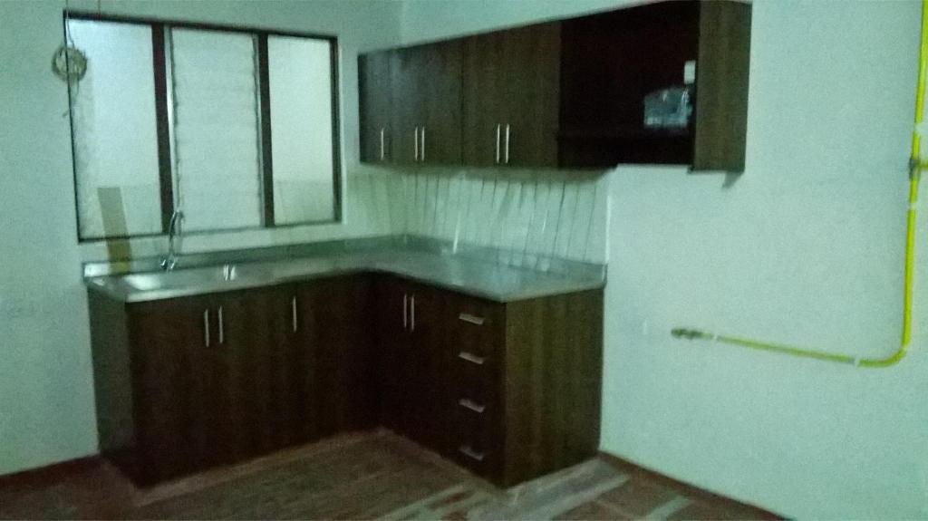 an empty kitchen with wooden cabinets and a sink at Apartamento cerca a Parque de Bello Antioquia in Bello