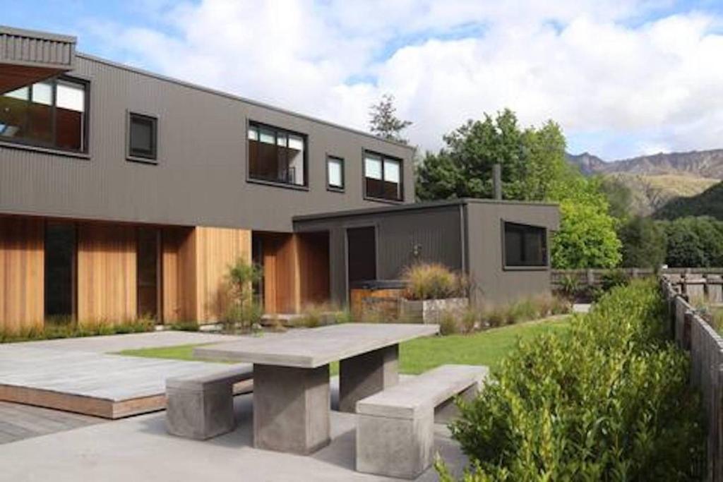 a house with a picnic table in front of it at Haehaenui Retreat - with Stoked hot tub in Arrowtown