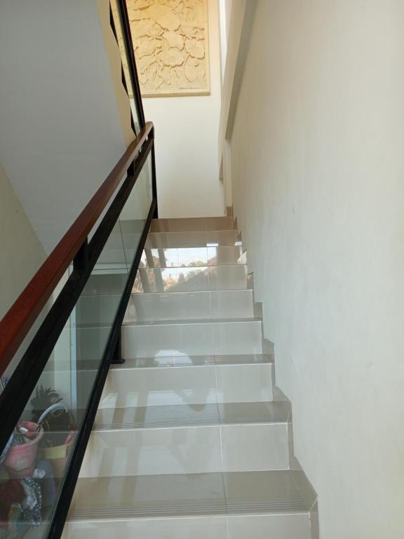 una escalera con barandilla de cristal y escalera en Erick house, en Seminyak