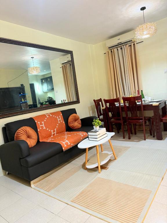 a living room with a black couch and a table at Chic &Cozy 3Bedroom House in Agus