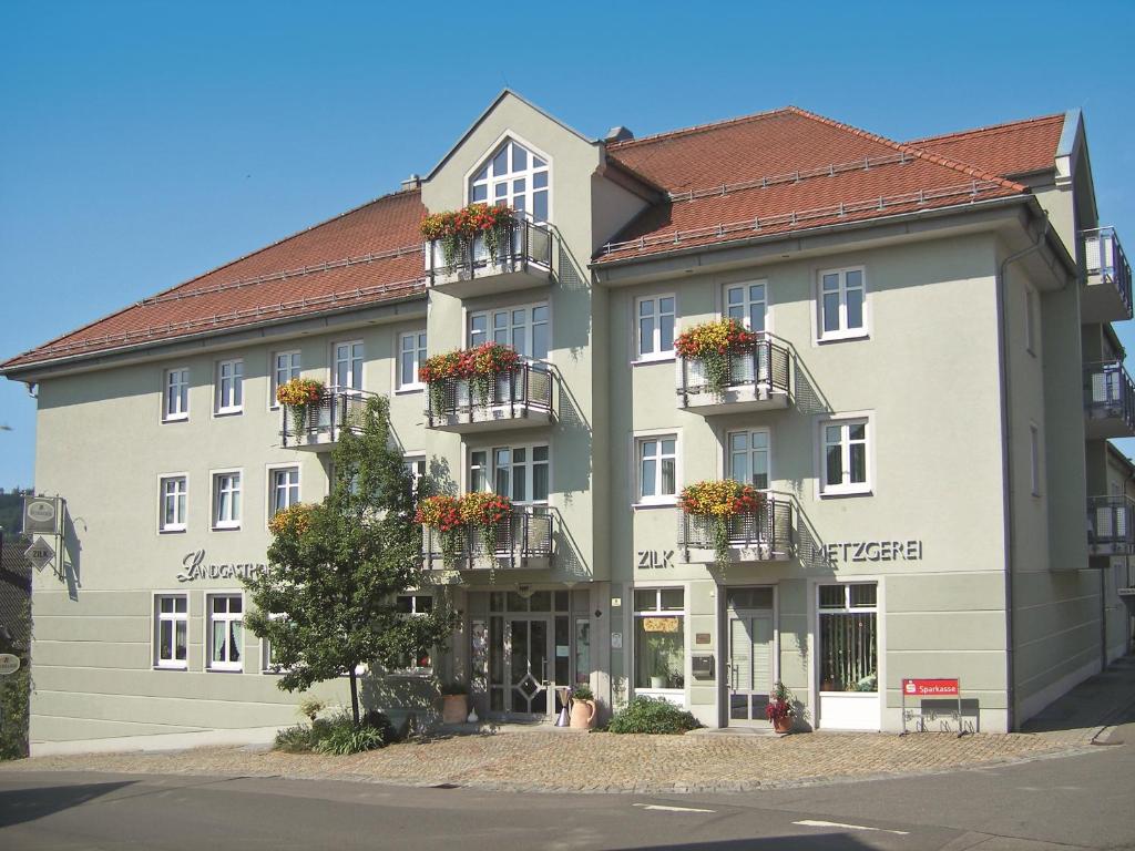 ein großes Gebäude mit Blumenkästen auf den Balkonen in der Unterkunft Zilks Landgasthof Zum Frauenstein in Weiding