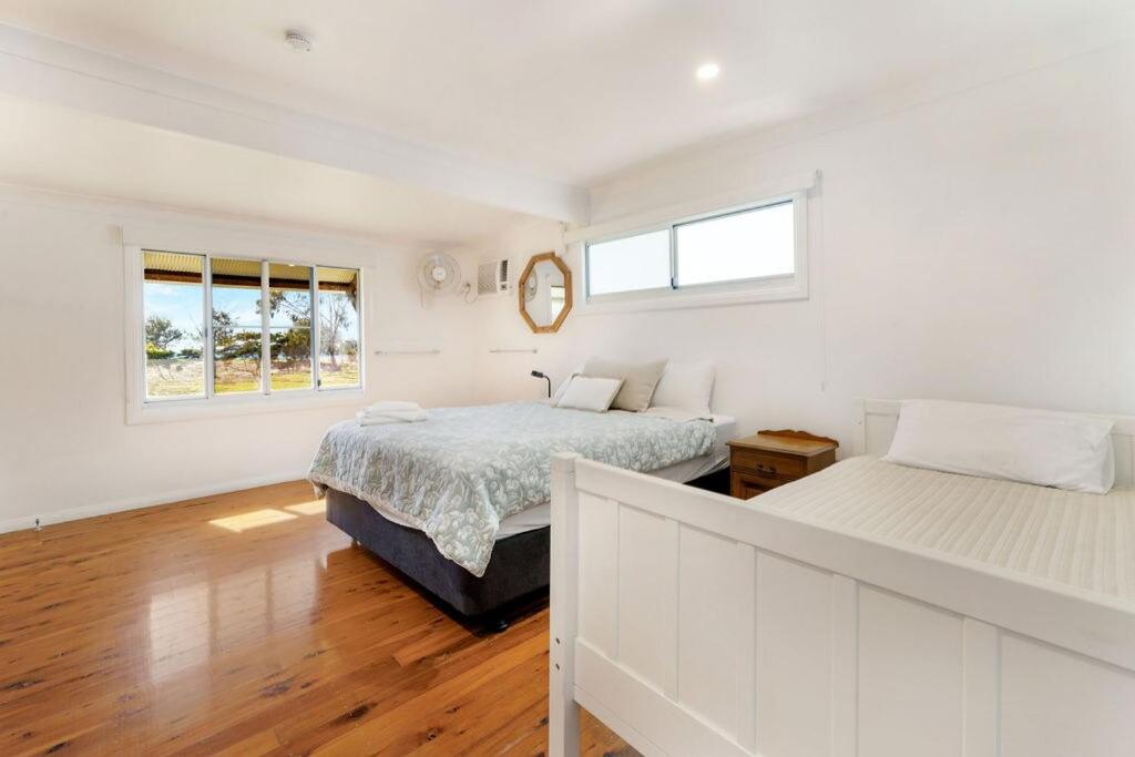 une chambre blanche avec deux lits et une fenêtre dans l'établissement Cottage 1 Cape Keppel Beach, à Curtis Island