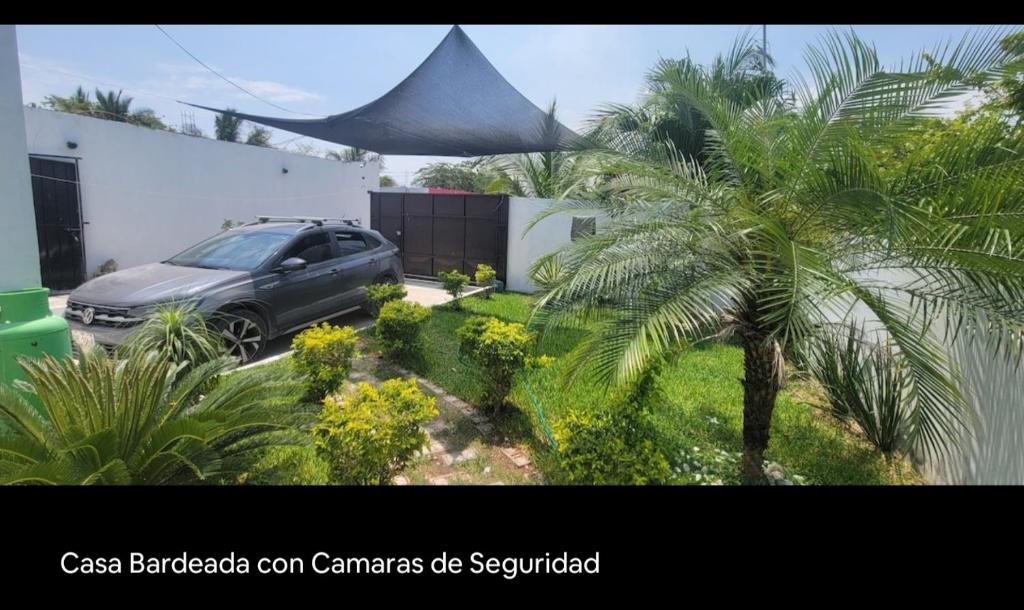 a car parked in front of a house with a palm tree at CASA con 2 habitaciones, Cocina,comedor y baño privados in Candelaria
