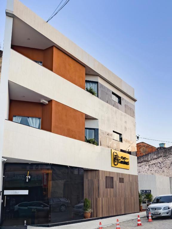 a building with cars parked outside of it at FLAT CAMBUCI - Hospedagem e Moradia - Centro de Ipiaú-BA in Ipiaú