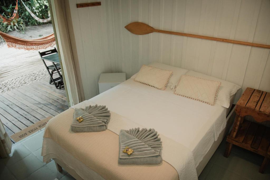 a bedroom with a bed with towels on it at Pousada Bela Vista in Ilha do Mel