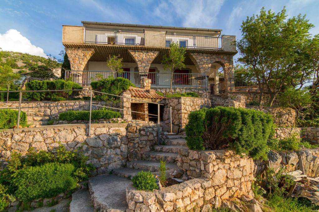 a stone house on a hill with stairs at Starigrad Apartment in Starigrad