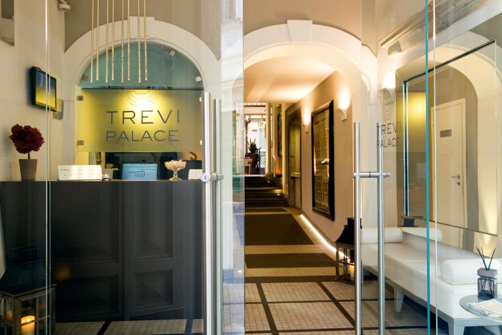 un couloir dans un bâtiment avec un panneau indiquant le palais des trex dans l'établissement Trevi Palace Luxury Inn, à Rome