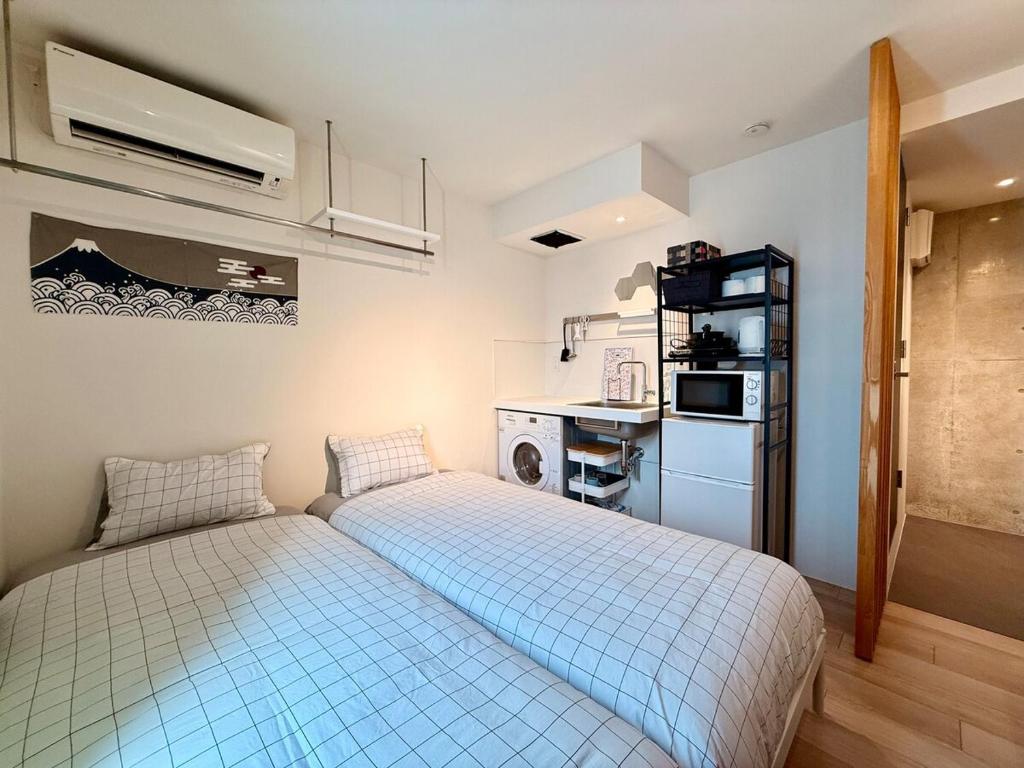 a small room with a bed and a kitchen at Shibuya Simplex 3F, sunlight and 2 beds in Tokyo