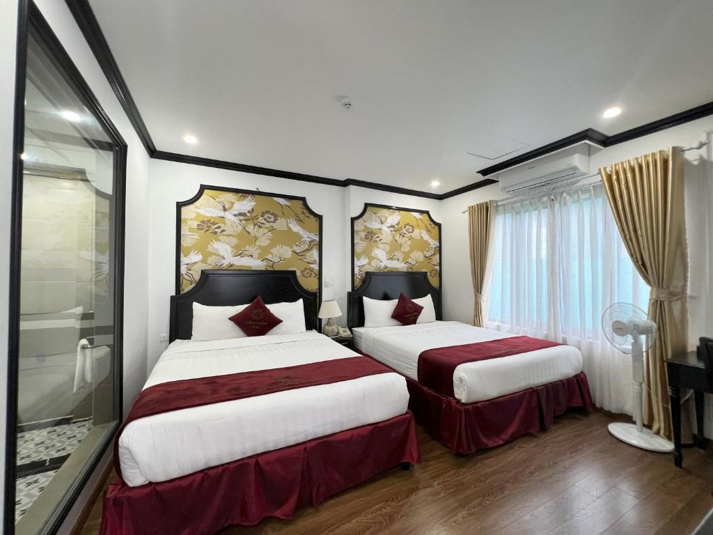 a bedroom with two beds with red and white sheets at HƯỚNG DƯƠNG HOTEL THANH HOÁ in Thanh Hóa