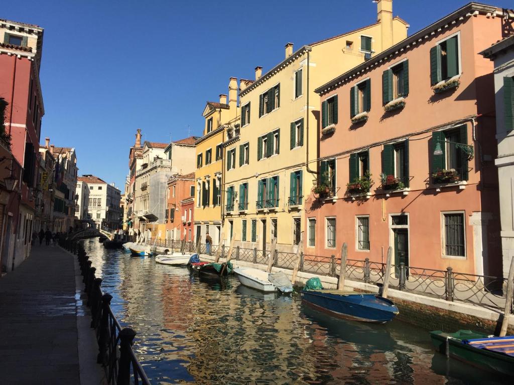 a group of boats in a canal between buildings at Cà Marin in Venice