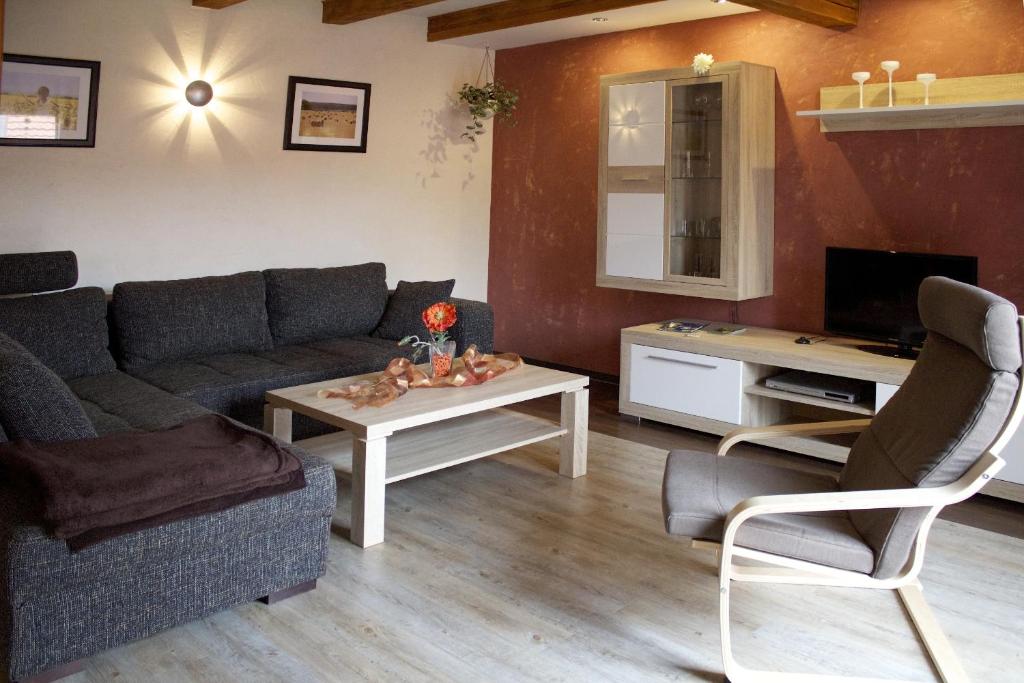 ein Wohnzimmer mit einem Sofa und einem Tisch in der Unterkunft Ferienwohnung zur Erlebnisschmiede in Kammerforst