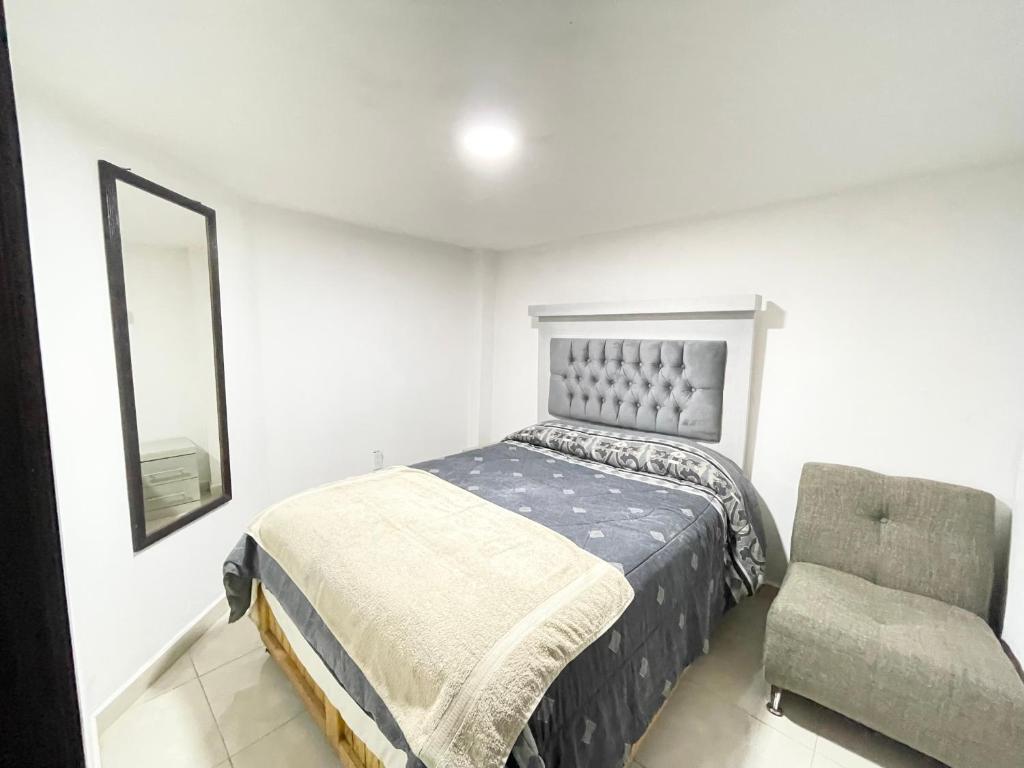 a bedroom with a bed and a chair at Departamento #2 Aeropuerto Toluca in Toluca