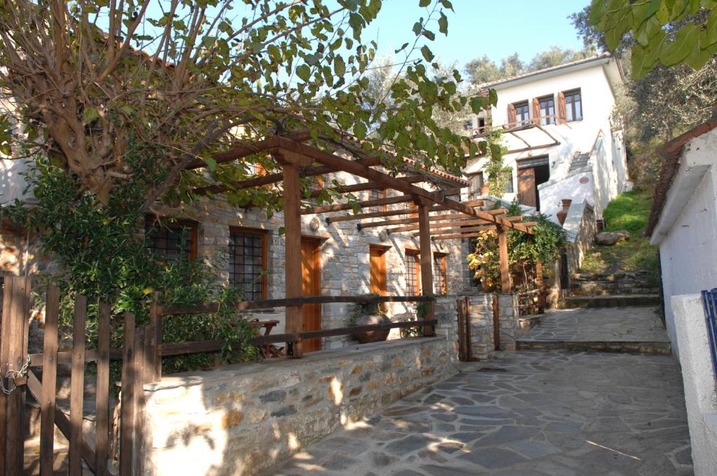 a wooden pergola in front of a house at erofili apartments in Kálamos