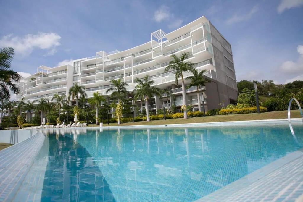 a large building with a swimming pool in front of it at Punta Mita Beachfront Ocean Views BOLONGO in Higuera Blanca