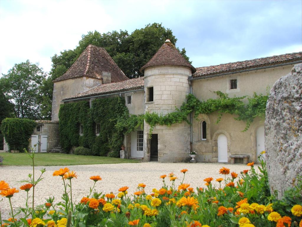 an old house with flowers in front of it at Château de la Tour du Breuil in Le Breuil