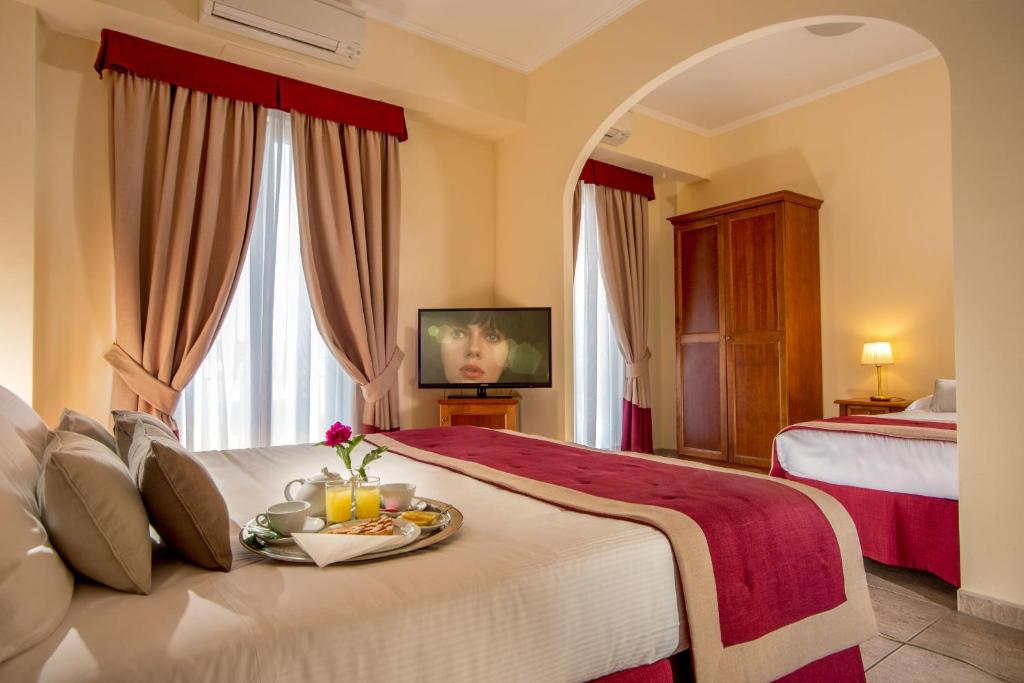 Una habitación de hotel con una cama con una bandeja de comida. en Marini Park Hotel, en Castel di Leva