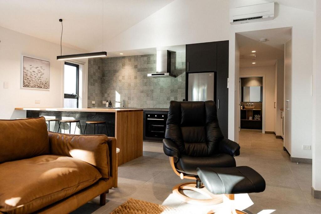 a living room with a couch and a kitchen at Villa 1 - Greenstone Villas in St Helens