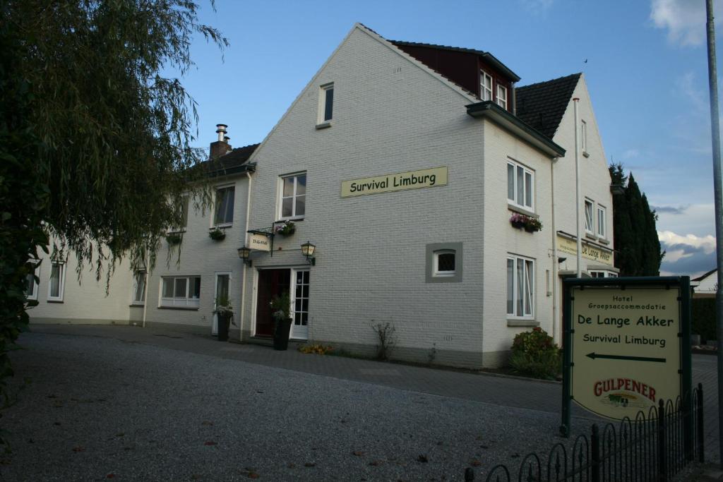 a white building with a sign in front of it at Hotel De Lange Akker in Berg en Terblijt