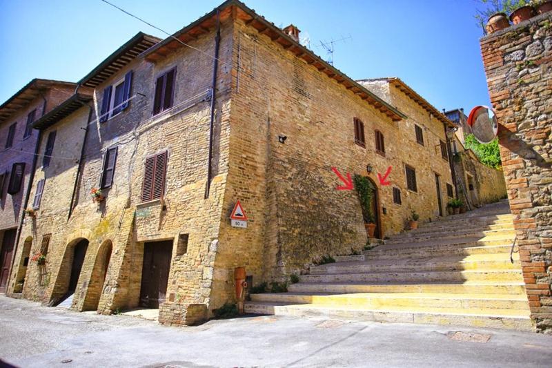 an old brick building with stairs leading up to it at Da Gina in San Gimignano
