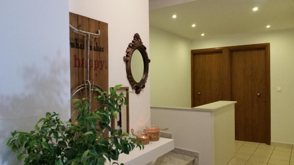 a bathroom with a mirror and a plant at Asprolithos Studios in Skiathos