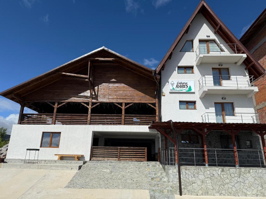 a large white building with a wooden roof at Cabana Rares in Ranca