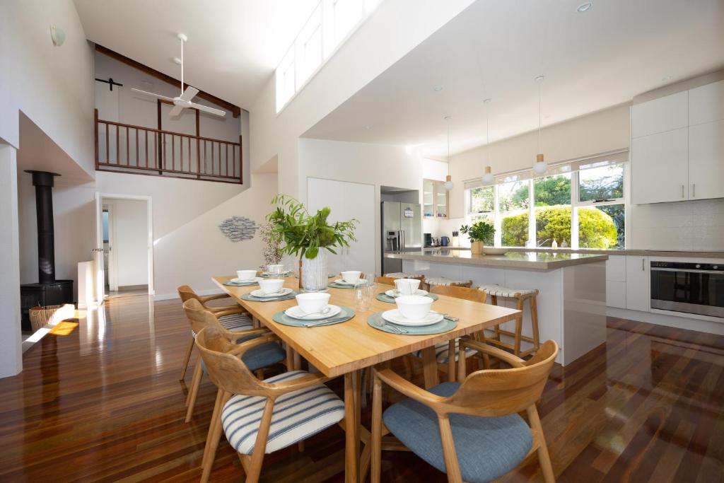 a kitchen and dining room with a wooden table and chairs at The Avenue in Anglesea