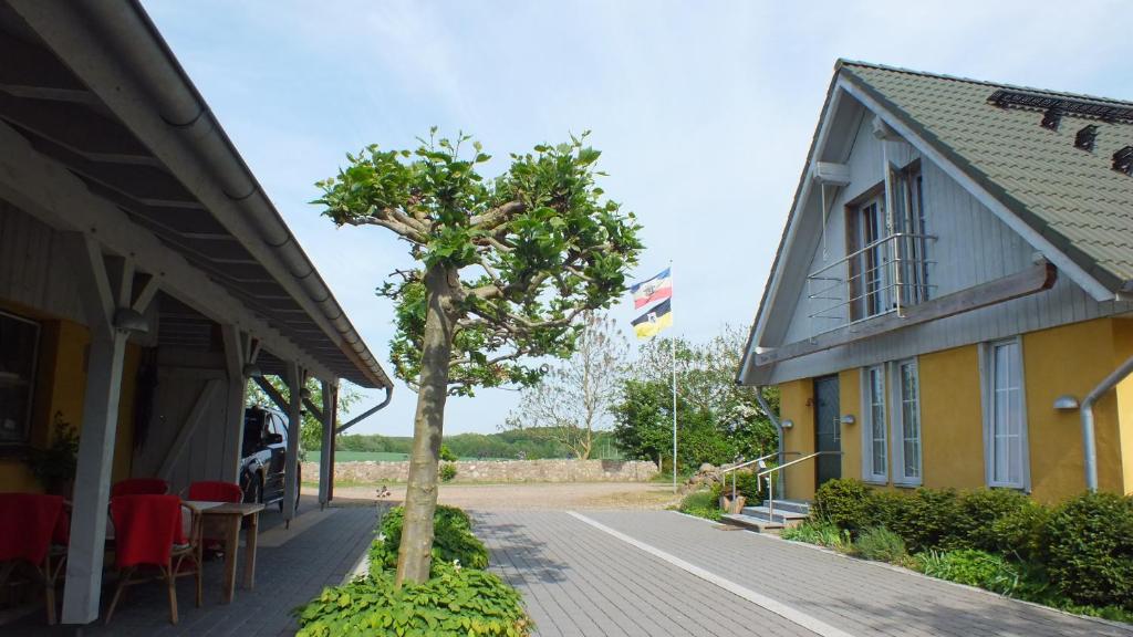 ein Haus mit einem Baum neben einem Gebäude mit einer Flagge in der Unterkunft Am See in Pastin