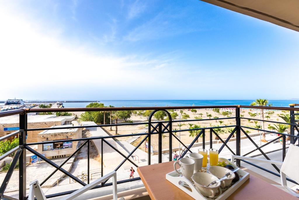 balcón con mesa y vistas a la playa en Aqua Marina, en Rethymno