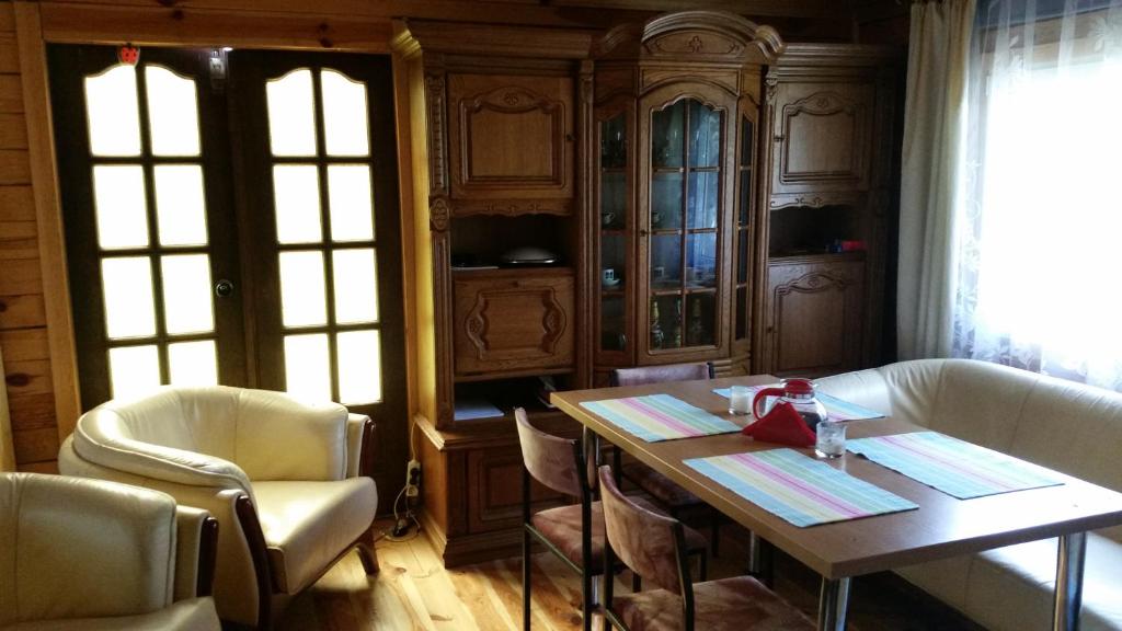 a room with a table and chairs and a kitchen at Dom na Mazurach in Spychowo