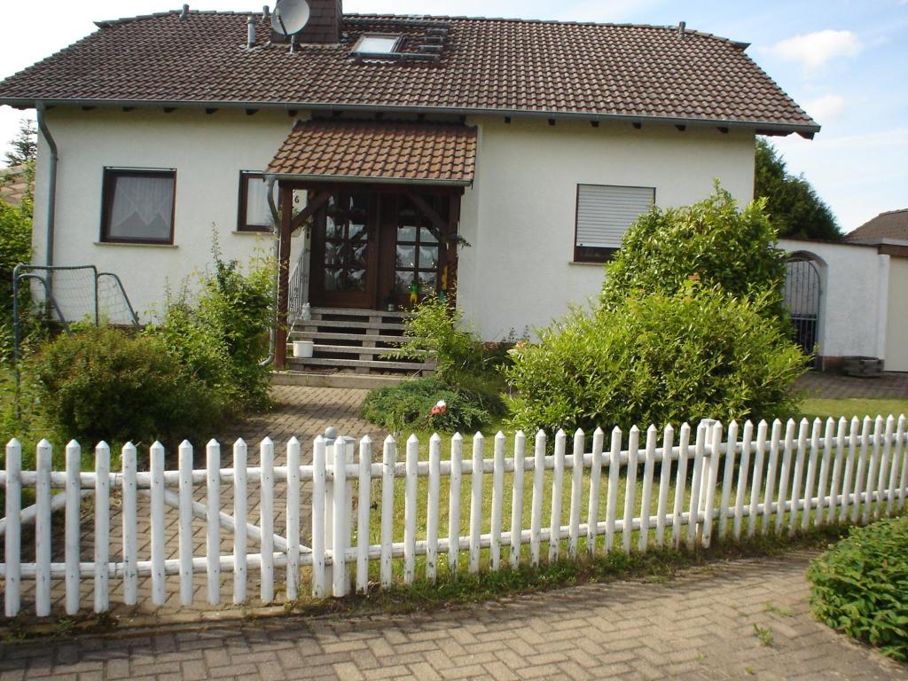 a white picket fence in front of a house at Ferienwohnung An der Loreley in Bornich
