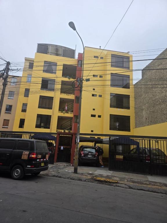 a yellow building with cars parked in front of it at RODRICH apartment 2 in Lima
