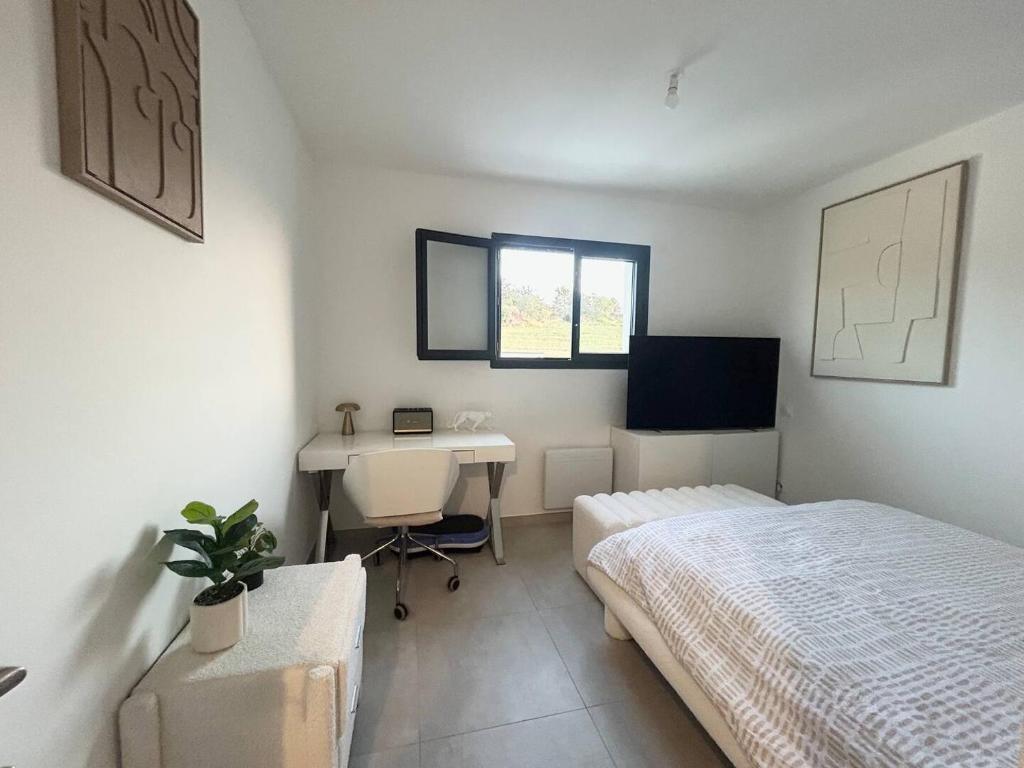 a bedroom with a bed and a desk in it at Belle chambre dans villa neuve avec piscine in Perpignan